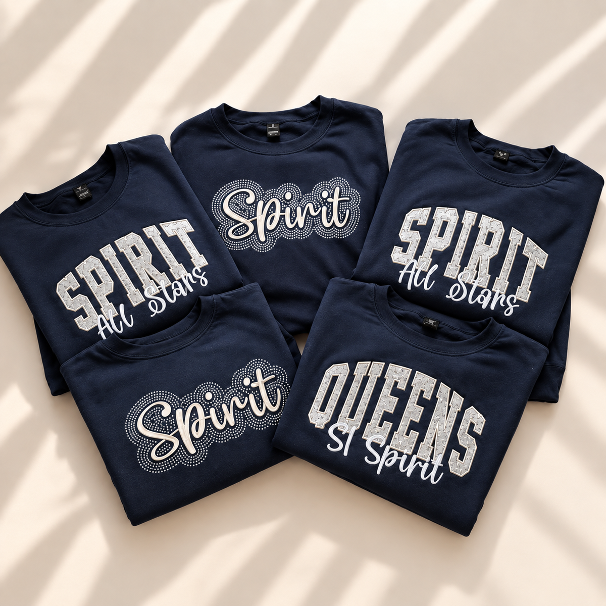 Coordinated navy team sweatshirts featuring appliqué, embroidered script, and rhinestone designs